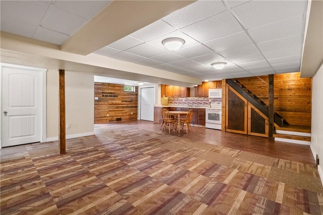 988 Croft Rd, Salem Twp Wml, PA 15601 - unfurnished living room with a paneled ceiling, stairway, wooden walls, wood finished floors, and baseboards