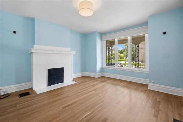 1105 Chislett St, Morningside, PA 15206 - unfurnished living room with a brick fireplace, baseboards, and wood finished floors
