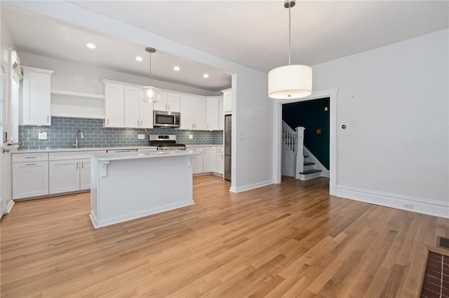 1105 Chislett St, Morningside, PA 15206 - kitchen with appliances with stainless steel finishes, open shelves, backsplash, light countertops, and a sink