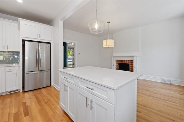 1105 Chislett St, Morningside, PA 15206 - kitchen with freestanding refrigerator, light wood finished floors, light countertops, white cabinetry, and decorative backsplash