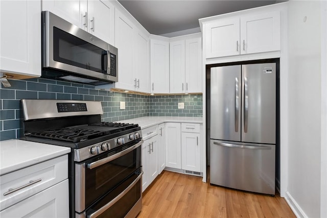1105 Chislett St, Morningside, PA 15206 - kitchen featuring stainless steel appliances, light countertops, light wood-style flooring, and white cabinets