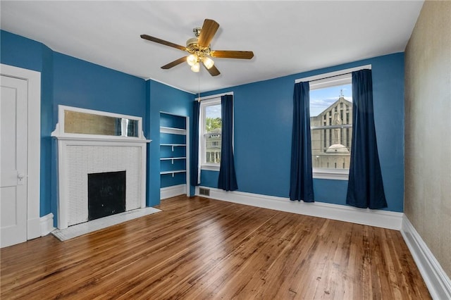 1105 Chislett St, Morningside, PA 15206 - unfurnished living room with built in shelves, a brick fireplace, wood finished floors, baseboards, and ceiling fan