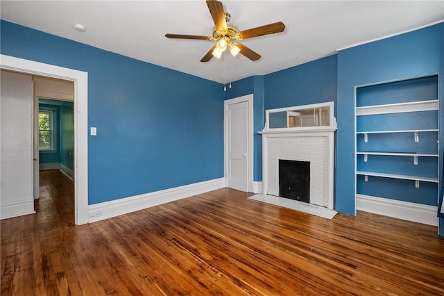 1105 Chislett St, Morningside, PA 15206 - unfurnished living room featuring ceiling fan, a fireplace, built in shelves, wood finished floors, and baseboards