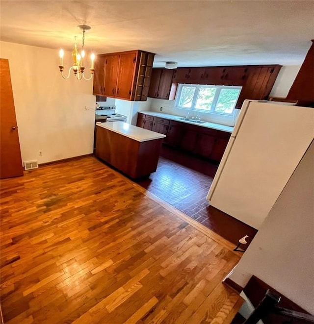 1720 Saltsburg Ave, White Twp Ind, PA 15701 - kitchen with dark wood finished floors, light countertops, a peninsula, a chandelier, and white range with electric stovetop