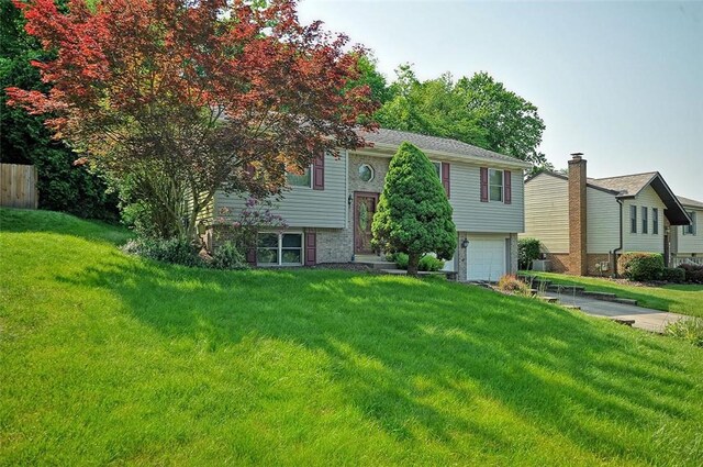 317 Fairview Dr, Manor, PA 15642 - raised ranch with an attached garage, a front lawn, and brick siding