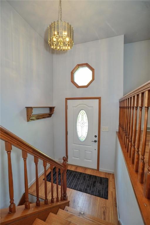 317 Fairview Dr, Manor, PA 15642 - entrance foyer featuring a chandelier, wood finished floors, stairs, and baseboards