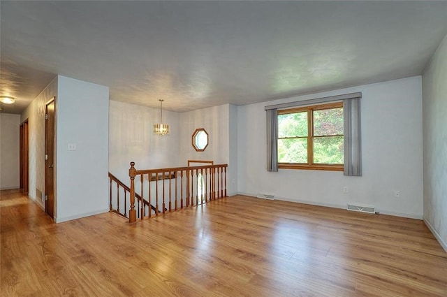 317 Fairview Dr, Manor, PA 15642 - empty room with wood finished floors, a chandelier, and baseboards