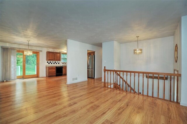 317 Fairview Dr, Manor, PA 15642 - unfurnished living room featuring a chandelier and light wood-style floors