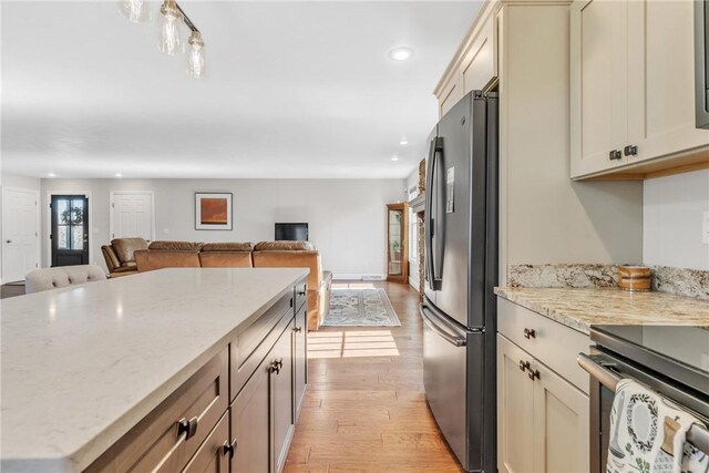 2246 Shannon Mills Dr, Connoquenessing Twp, PA 16053 - kitchen with stainless steel appliances, open floor plan, light wood-style flooring, recessed lighting, and light stone counters
