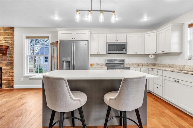 2246 Shannon Mills Dr, Connoquenessing Twp, PA 16053 - kitchen featuring stainless steel appliances, a sink, light countertops, a kitchen bar, and a kitchen island