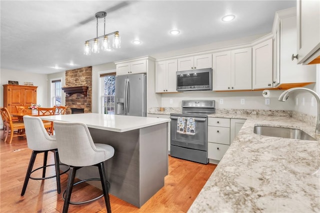 2246 Shannon Mills Dr, Connoquenessing Twp, PA 16053 - kitchen featuring appliances with stainless steel finishes, a sink, a kitchen breakfast bar, a center island, and white cabinets