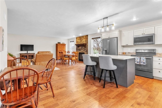 2246 Shannon Mills Dr, Connoquenessing Twp, PA 16053 - kitchen featuring stainless steel appliances, a kitchen island, light countertops, white cabinetry, and open floor plan