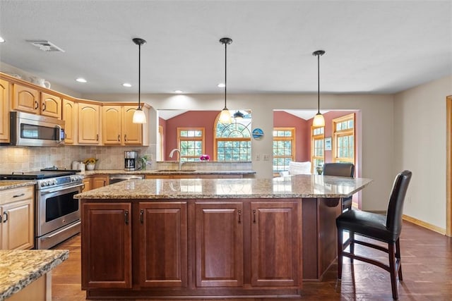 1616 Norman Dr, Franklin Park, PA 15143 - kitchen featuring appliances with stainless steel finishes, a kitchen island, dark wood-style floors, a kitchen breakfast bar, and recessed lighting