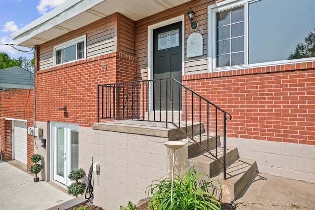 162 E Wedgewood Dr, Ross Twp, PA 15229 - view of exterior entry featuring brick siding, driveway, and a garage