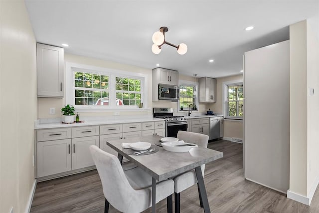 162 E Wedgewood Dr, Ross Twp, PA 15229 - kitchen with stainless steel appliances, baseboards, wood finished floors, a sink, and light countertops
