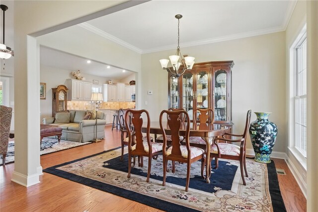 112 Savannah Dr, Lancaster Twp, PA 16037 - dining room with a chandelier, light wood finished floors, ornamental molding, and baseboards