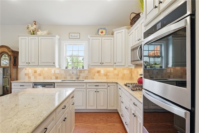112 Savannah Dr, Lancaster Twp, PA 16037 - kitchen featuring a sink, stainless steel appliances, backsplash, light stone countertops, and white cabinets