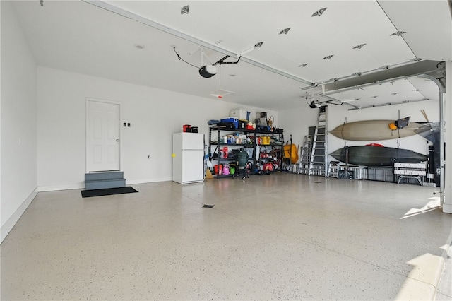 112 Savannah Dr, Lancaster Twp, PA 16037 - garage featuring freestanding refrigerator, a garage door opener, and baseboards