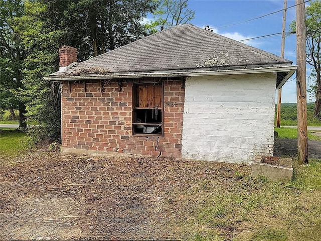 214 Washington Ave, Mount Pleasant Twp Was, PA 15340 - view of side of property featuring roof with shingles, a chimney, and brick siding