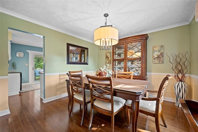 208 Ruffed Grouse Dr, North Fayette, PA 15126 - dining area featuring wainscoting, dark wood-type flooring, ornamental molding, and a textured ceiling