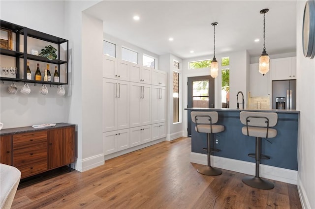 323 44th St, Lawrenceville, PA 15201 - kitchen featuring stainless steel fridge, a breakfast bar area, light wood finished floors, baseboards, and recessed lighting