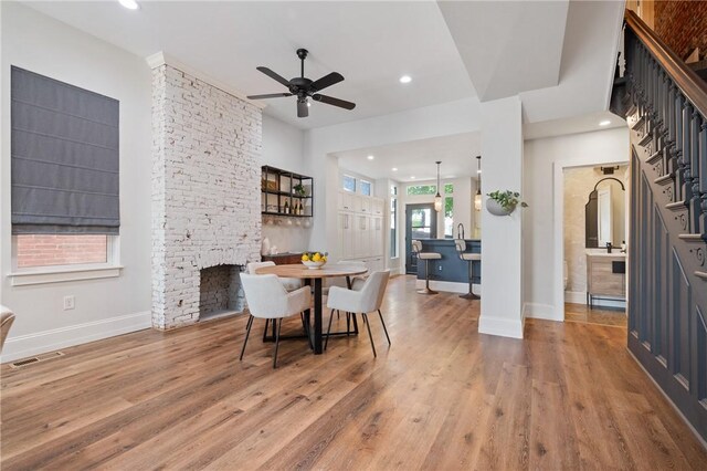 323 44th St, Lawrenceville, PA 15201 - dining area with ceiling fan, light wood finished floors, baseboards, recessed lighting, and a fireplace
