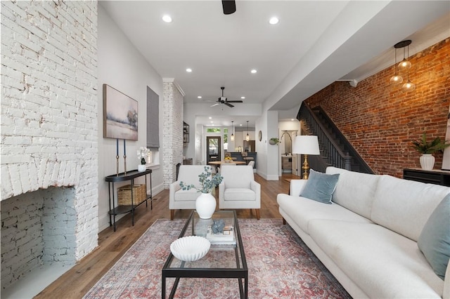 323 44th St, Lawrenceville, PA 15201 - living area featuring ceiling fan, wood finished floors, stairway, recessed lighting, and brick wall