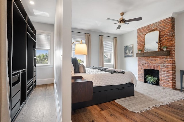 323 44th St, Lawrenceville, PA 15201 - bedroom with wood finished floors, baseboards, a fireplace, and ceiling fan