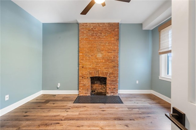 323 44th St, Lawrenceville, PA 15201 - unfurnished living room featuring ceiling fan, wood finished floors, a fireplace, and baseboards