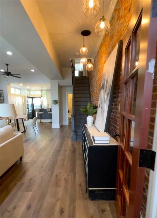 323 44th St, Lawrenceville, PA 15201 - interior space with wood finished floors, baseboards, a ceiling fan, and brick wall