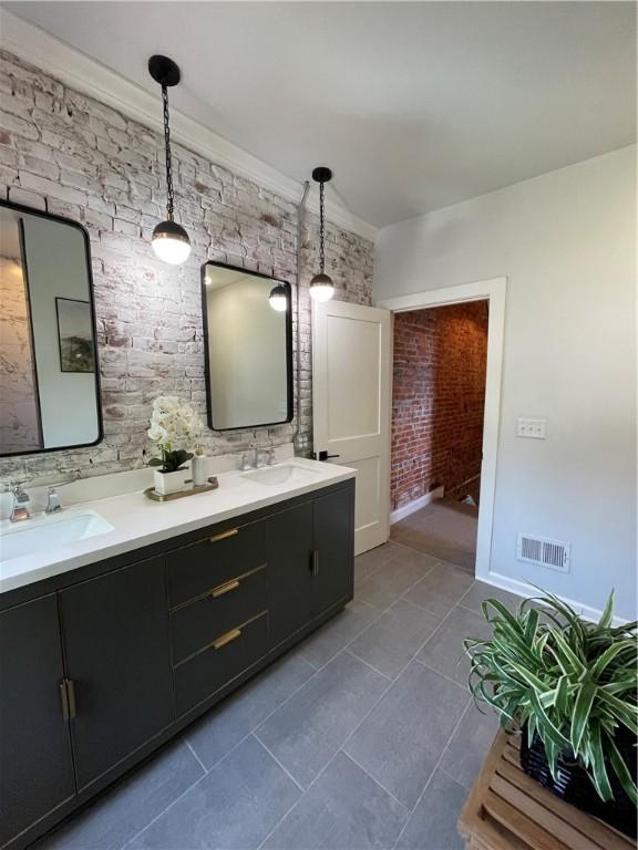 323 44th St, Lawrenceville, PA 15201 - bathroom featuring tile patterned floors, double vanity, and baseboards