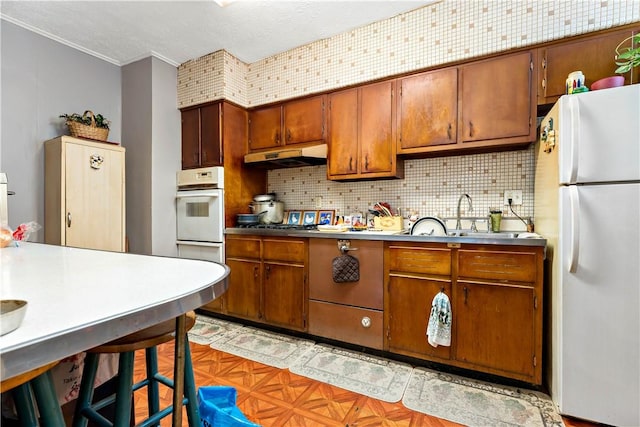 3 Boggs Ave, Mt Washington, PA 15211 - kitchen featuring white appliances, a sink, under cabinet range hood, brown cabinets, and ornamental molding