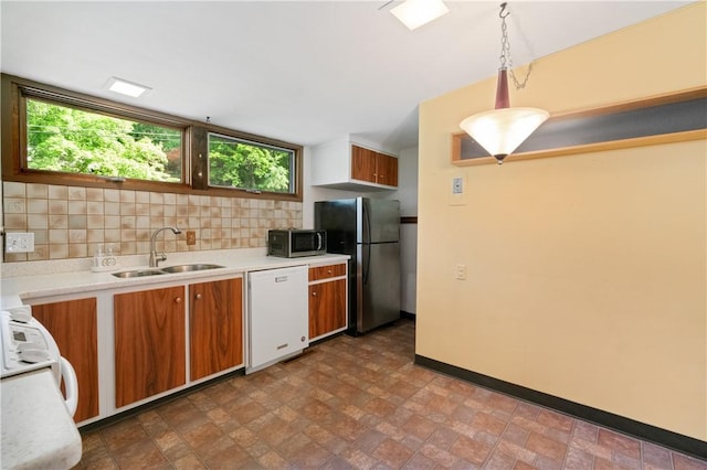 102 Colwyn Rd, Ross Twp, PA 15237 - kitchen with stainless steel appliances, a sink, brown cabinets, light countertops, and baseboards