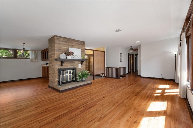 102 Colwyn Rd, Ross Twp, PA 15237 - unfurnished living room with light wood-style floors, a brick fireplace, a ceiling fan, and baseboards