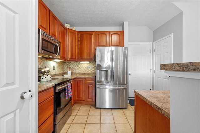 254 Maple Ridge Dr, Cecil, PA 15317 - kitchen with appliances with stainless steel finishes, light tile patterned floors, backsplash, a textured ceiling, and brown cabinetry