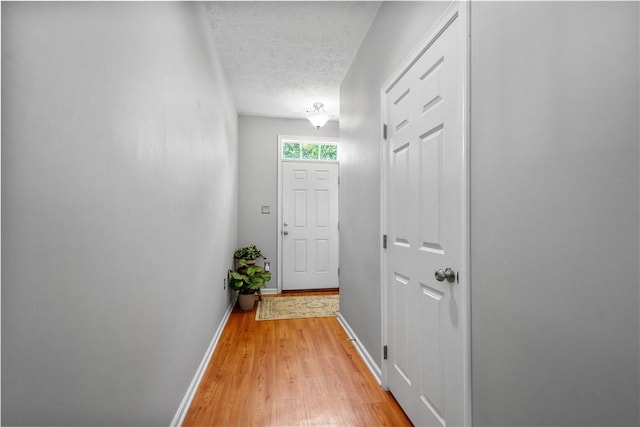 254 Maple Ridge Dr, Cecil, PA 15317 - doorway to outside featuring light wood finished floors, baseboards, and a textured ceiling
