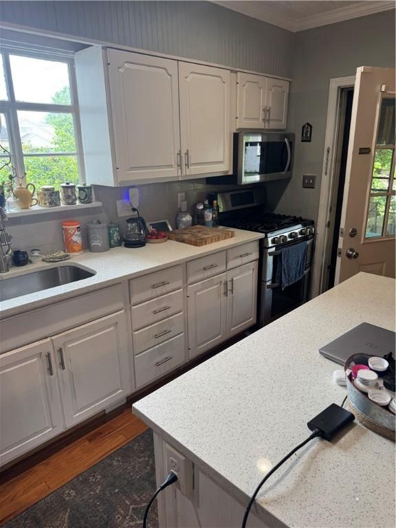 623 5th St, Oakmont, PA 15139 - kitchen with stainless steel appliances, crown molding, light countertops, a sink, and white cabinets