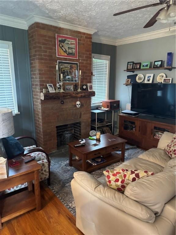 623 5th St, Oakmont, PA 15139 - living area with a ceiling fan, wood finished floors, crown molding, a brick fireplace, and a textured ceiling