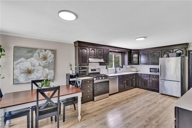 169 Plum Way, Wayne Twp Law, PA 16157 - kitchen with stainless steel appliances, under cabinet range hood, light countertops, decorative backsplash, and light wood-style flooring