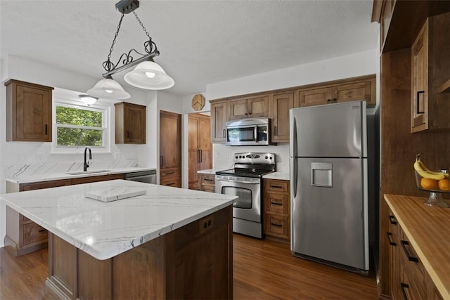 113 Silo Ct, North Fayette, PA 15071 - kitchen featuring stainless steel appliances, a sink, dark wood-style flooring, decorative light fixtures, and a textured ceiling
