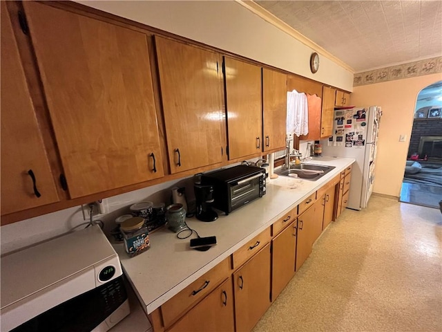 807 Sutton St, Punxsutawney Area School District, PA 15767 - kitchen featuring crown molding, white appliances, light countertops, arched walkways, and a sink