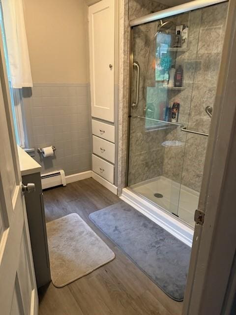 111 Central Ave, Chicora Boro, PA 16025 - bathroom featuring baseboard heating, wood finished floors, vanity, a shower stall, and tile walls