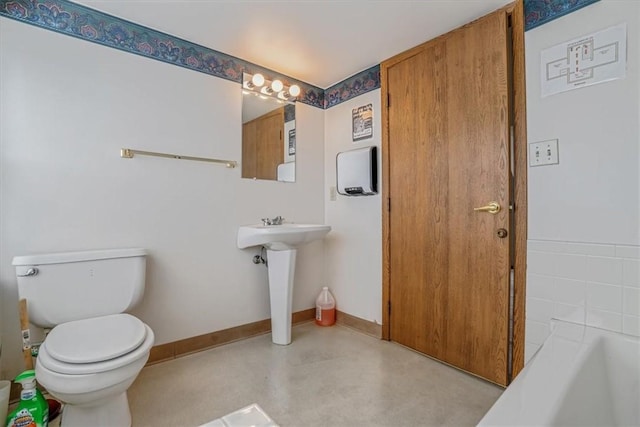 1632 Lincoln Way, White Oak, PA 15131 - bathroom featuring toilet, a tub to relax in, finished concrete floors, a sink, and baseboards
