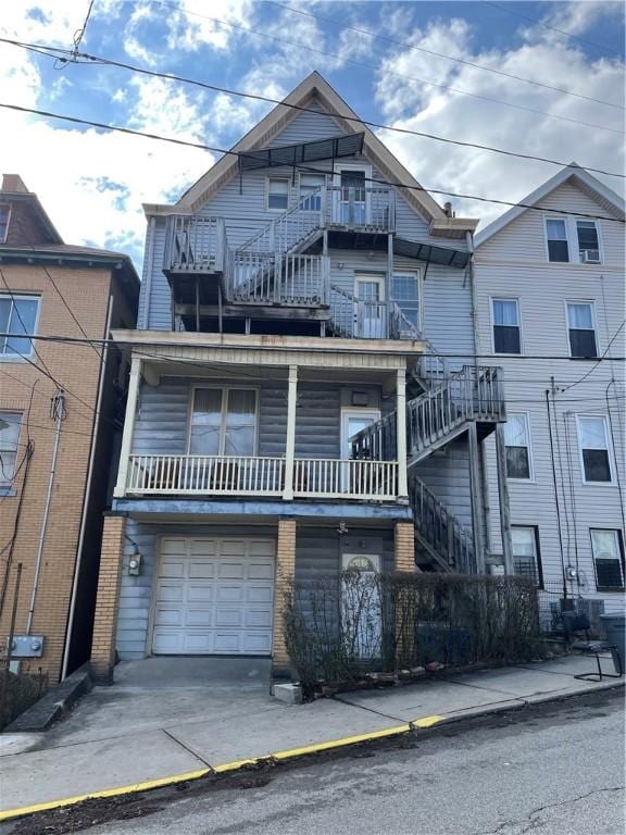 3884 E St, Perry Hilltop, PA 15214 - townhome / multi-family property with a garage, concrete driveway, a balcony, and stairs