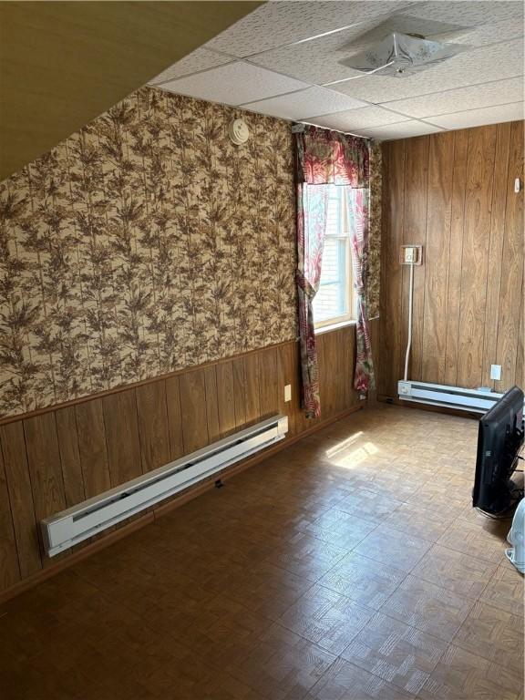 3884 E St, Perry Hilltop, PA 15214 - spare room with a baseboard heating unit, wallpapered walls, wooden walls, a wainscoted wall, and a paneled ceiling