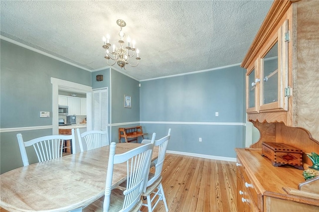 429 Market St, Beaver, PA 15009 - dining space with a chandelier, light wood finished floors, a textured ceiling, crown molding, and baseboards