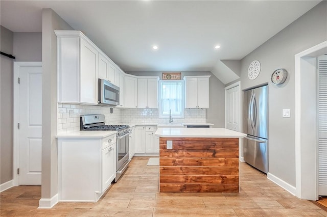 429 Market St, Beaver, PA 15009 - kitchen featuring appliances with stainless steel finishes, a sink, light countertops, backsplash, and white cabinetry