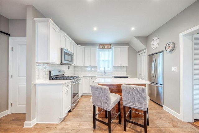 429 Market St, Beaver, PA 15009 - kitchen with appliances with stainless steel finishes, a center island, decorative backsplash, light countertops, and white cabinets