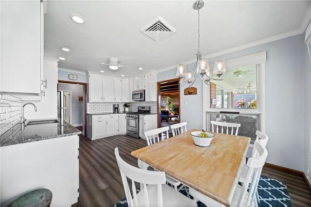 10756 Aldina Dr, Conneaut Lake, PA 16316 - dining room with crown molding, dark wood-style floors, recessed lighting, ceiling fan, and a chandelier