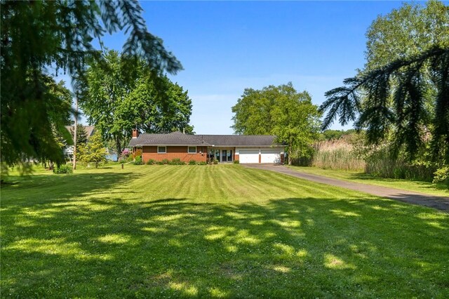 10756 Aldina Dr, Conneaut Lake, PA 16316 - ranch-style home featuring a garage, asphalt driveway, a front lawn, and a chimney